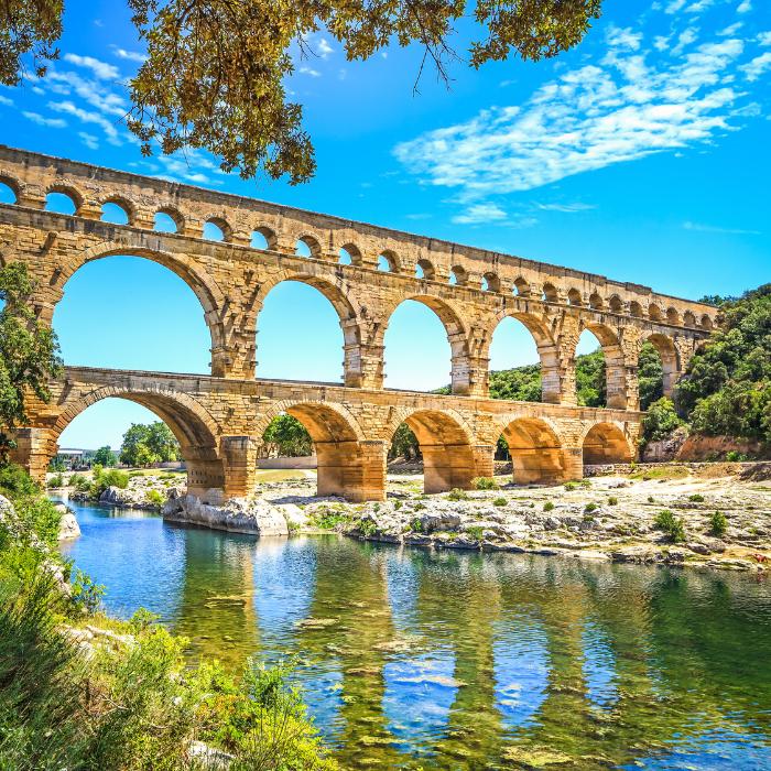 The Roman Pont du Gard aqueduct reflected in the river